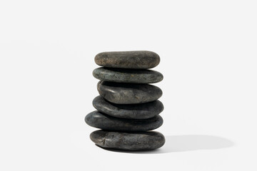 Stacked black spa pebbles on white background