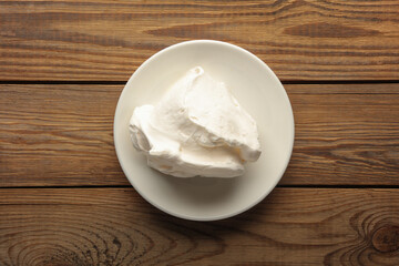 Large piece of meringue on a plate, wooden table