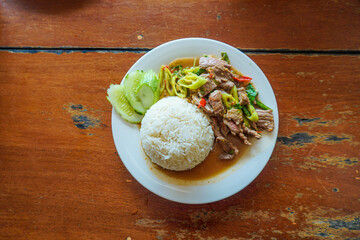 Stir fried beef and chili with meat and basil, chopped chili and garlic served with steam rice. Thai food.