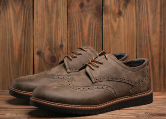 Pair of stylish men's brogue shoes on a wooden background