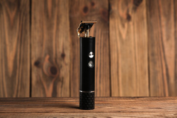 Cordless hair trimmer on wooden background