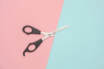 haircutting scissors on pink background