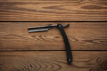 Straight razor on wooden table