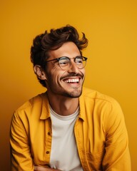 Fototapeta premium Portrait of a smiling man wearing glasses, yellow background Optics and eyewear concepts