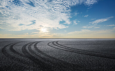 Fototapeta na wymiar Empty racing track road with drift traces and sky background