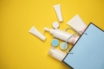Blue cardboard bag with cosmetics on a yellow background