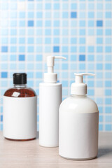 Bottles of cosmetics in bathroom on tile background