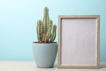 Cactus pot and photo frame on the table. Home decor