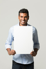 Indian man holding up a banner.