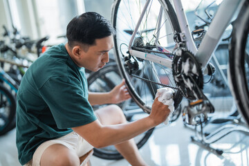 young man washing bicycle wheel rims at a bicycle shop