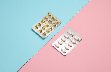 Blisters of tablets and pills on a blue pink background