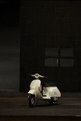 Photo of an old miniature scooter. Photographed with a green background to isolate the gray scooter object