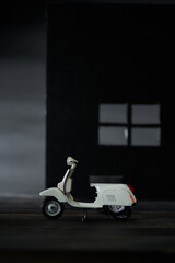 Photo of an old miniature scooter. Photographed with a green background to isolate the gray scooter object