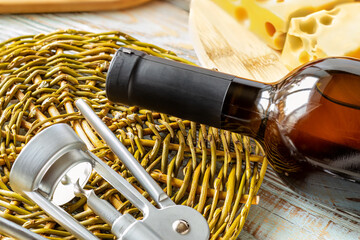 Close-up of neck of an unopened wine bottle and corkscrew. Wine Bottle Shrink Cap. Closed bottle of...
