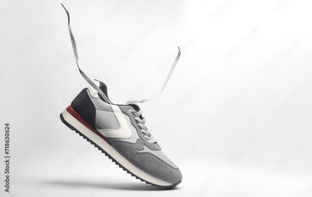 Wall mural Sport sneakers with flying laces on a white background