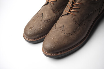 Brogue shoes with water drops on a white background. Shoe protection