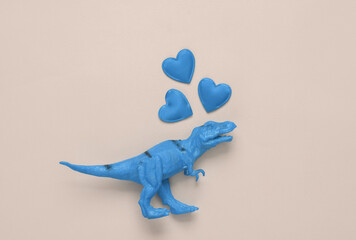 Toy tyrannosaurus rex with hearts on pink background. Romantic, love, valentine's day concept