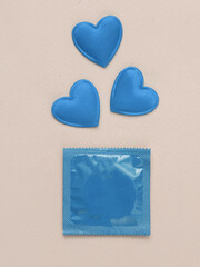 Love, sex concept. Blue Condom package with hearts on a pink background