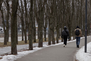 Fototapeta na wymiar Kyiv, Ukraine - January 20, 2024:cozy sleeping district of Borshchagivka. people are walking in the park on a day off.There are many different trees in Yunist Park. is located near residential buildin
