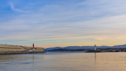 Fototapeta na wymiar Port scenery with a beautiful sunset - Breakwater and lighthouse