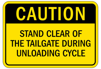 Truck warning sign and labels stand clear of the tailgate during unloading cycle