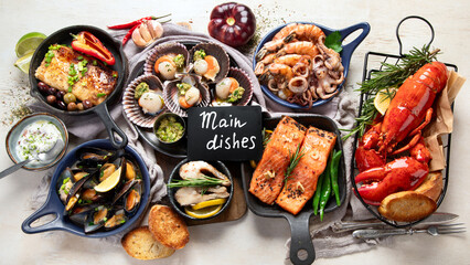 Set of Seafood dishes on light wooden background.
