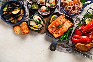 Set of Seafood dishes on light wooden background.