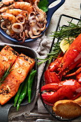 Set of Seafood dishes on light wooden background.