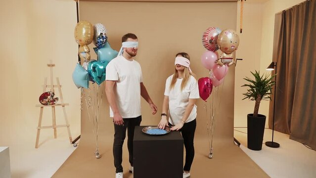 A man and a woman are celebrating a gender party. A married couple smears paint on each other to find out who the child is. The concept of a gender party. It’s a boy!