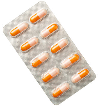 Orange capsules in the plastic blister, isolated on white background, top view.