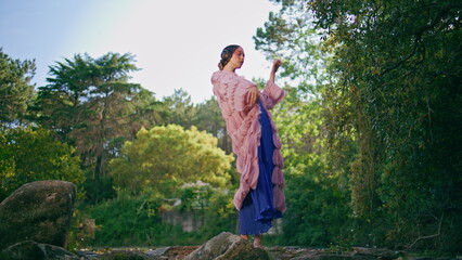 Glamorous girl standing forest lake in original clothing. Fantasy model posing 