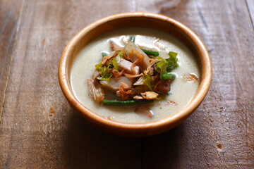 a bowl of sayur nangka muda in wooden background 