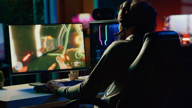 Player reaching final mission in coop FPS videogame, battling flying robots with his online friends. Gamer playing first person shooter game, fighting final boss helped by internet teammates