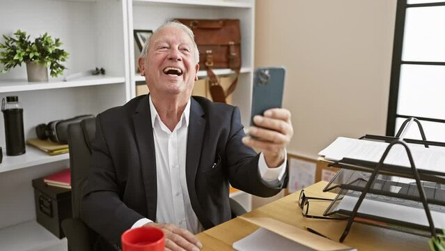Confident senior man enjoy taking work selfie with smartphone in office indoors