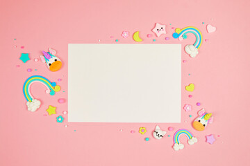 Blank white card on pastel pink background with frame of cute kawaii air plasticine handmade...