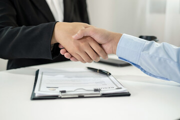 Friendly businessmen and executives shake hands after successful agreement with employment contracts, recruitment, and employment concepts