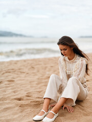 Fototapeta na wymiar Summer Serenity: A Beautiful Caucasian Woman Sitting Alone on a Sunny Beach, Enjoying the Tranquil Blue Sea and White Sandy Coast