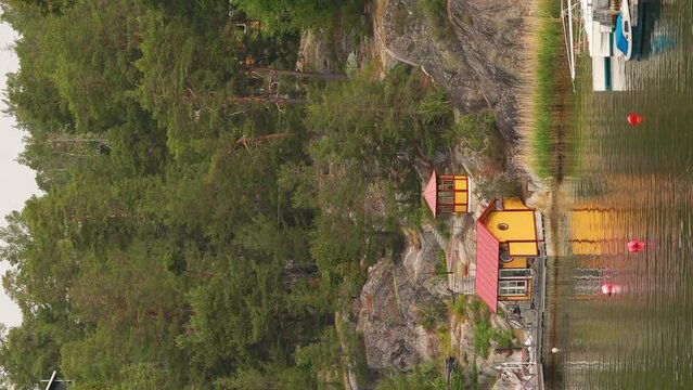 Red Scandic Wooden Houses On Island Coast In Summer Cloudy Day. Vertical Footage Video Hyperlapse. Nordic Architecture. Scandinavian Culture And Nature. Travel Concept To Sweden.