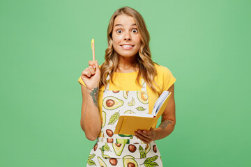 Young surprised housewife housekeeper chef baker woman wear apron yellow t-shirt hold in hand write...