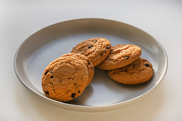 Oatmeal raisin cookies on a gray ceramic plate. Natural sunlight. Beautiful shadow