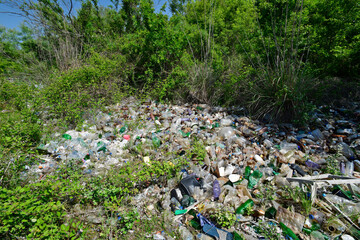 Wild rubbish dump with hundreds of plastic bottles in the countryside
