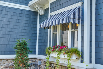 Cozy House Window with Blue Awning and Flower Box