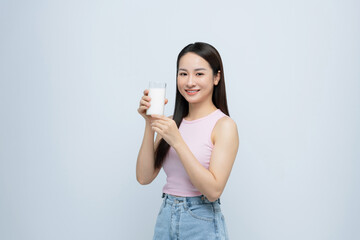 young girl holds glass of milk