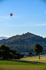 Hot Air Balloon Floating Above a Forested Hill