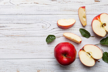 Fresh red apples with green leaves on wooden table. On wooden background. Top view free space for text