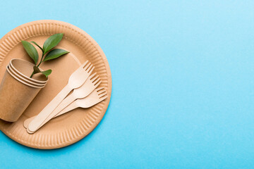 set of empty reusable disposable eco-friendly plates, cups, utensils on light white colored table background. top view. Biodegradable craft dishes. Recycling concept. Close-up