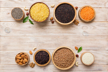 Various superfoods in smal bowl on colored background. Superfood as rice, chia, quinoa, lentils, nuts, sesame seeds, almonds. top view copy space