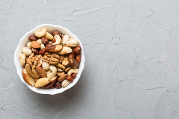 mixed nuts in bowl. Mix of various nuts on colored background. pistachios, cashews, walnuts, hazelnuts, peanuts and brazil nuts