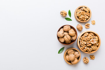 Walnut kernel halves, in a wooden bowl. Close-up, from above on colored background. Healthy eating Walnut concept. Super foods with copy space