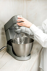 Food processor in the kitchen, with women's hands, side view